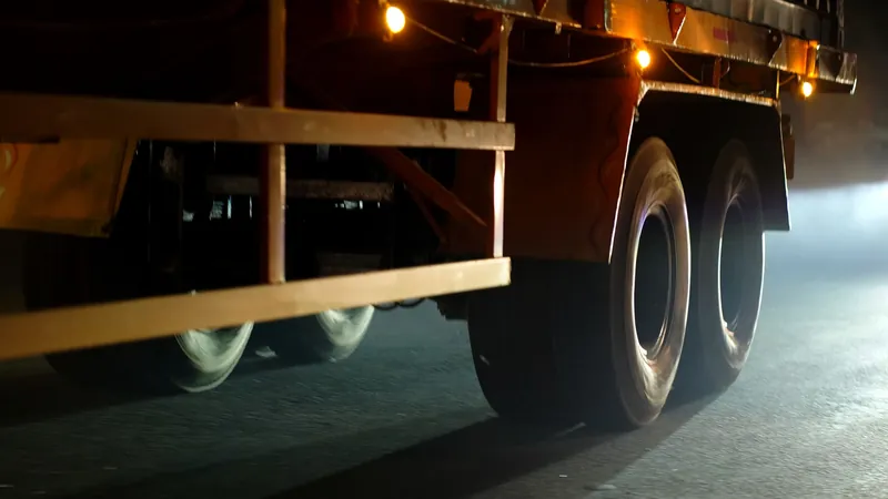 Close-up of truck wheels rolling along a road at night